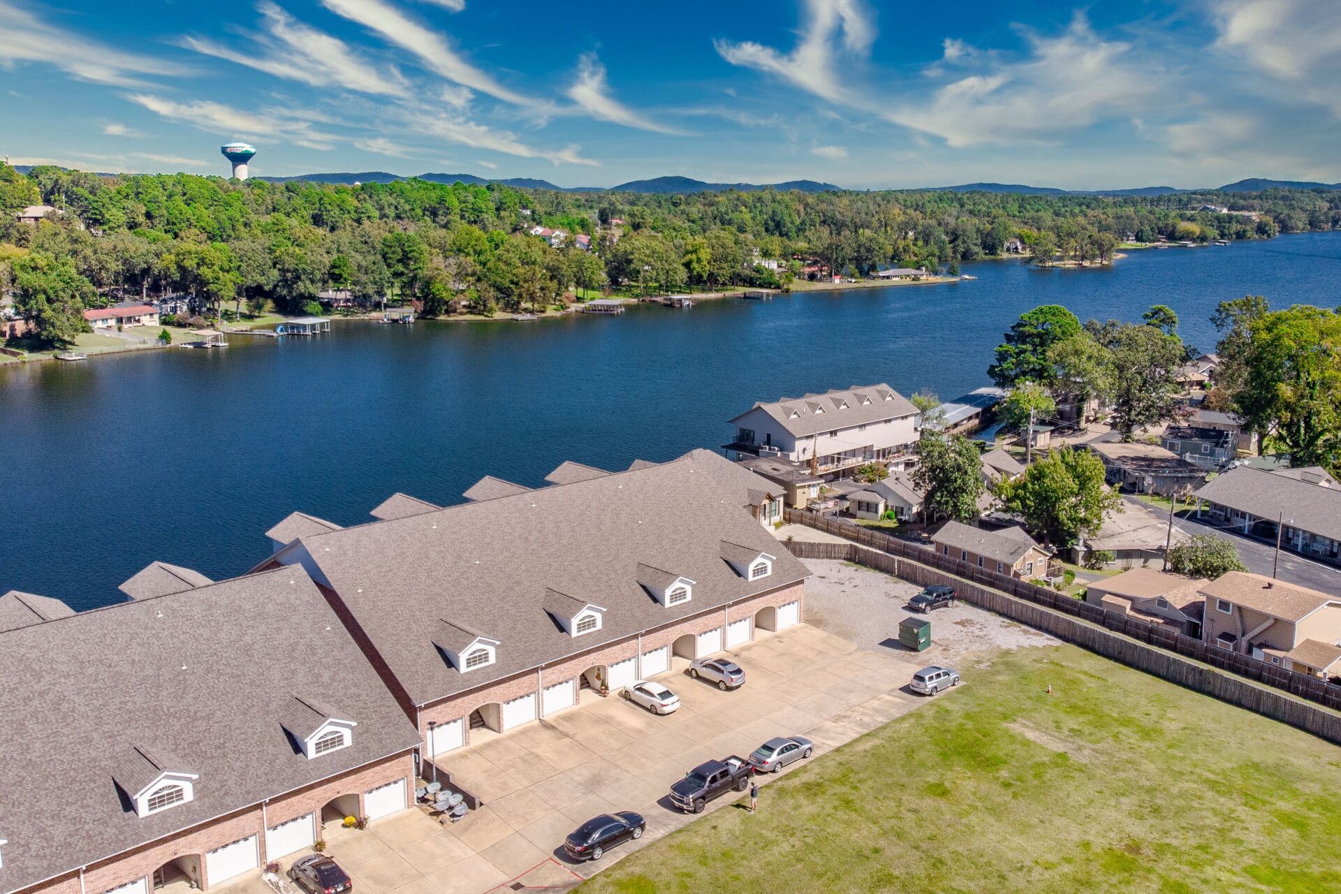 An aerial view of a row of houses next to a lake.