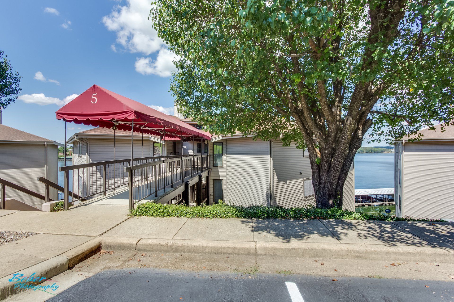 A building with a red awning over it is next to a lake.