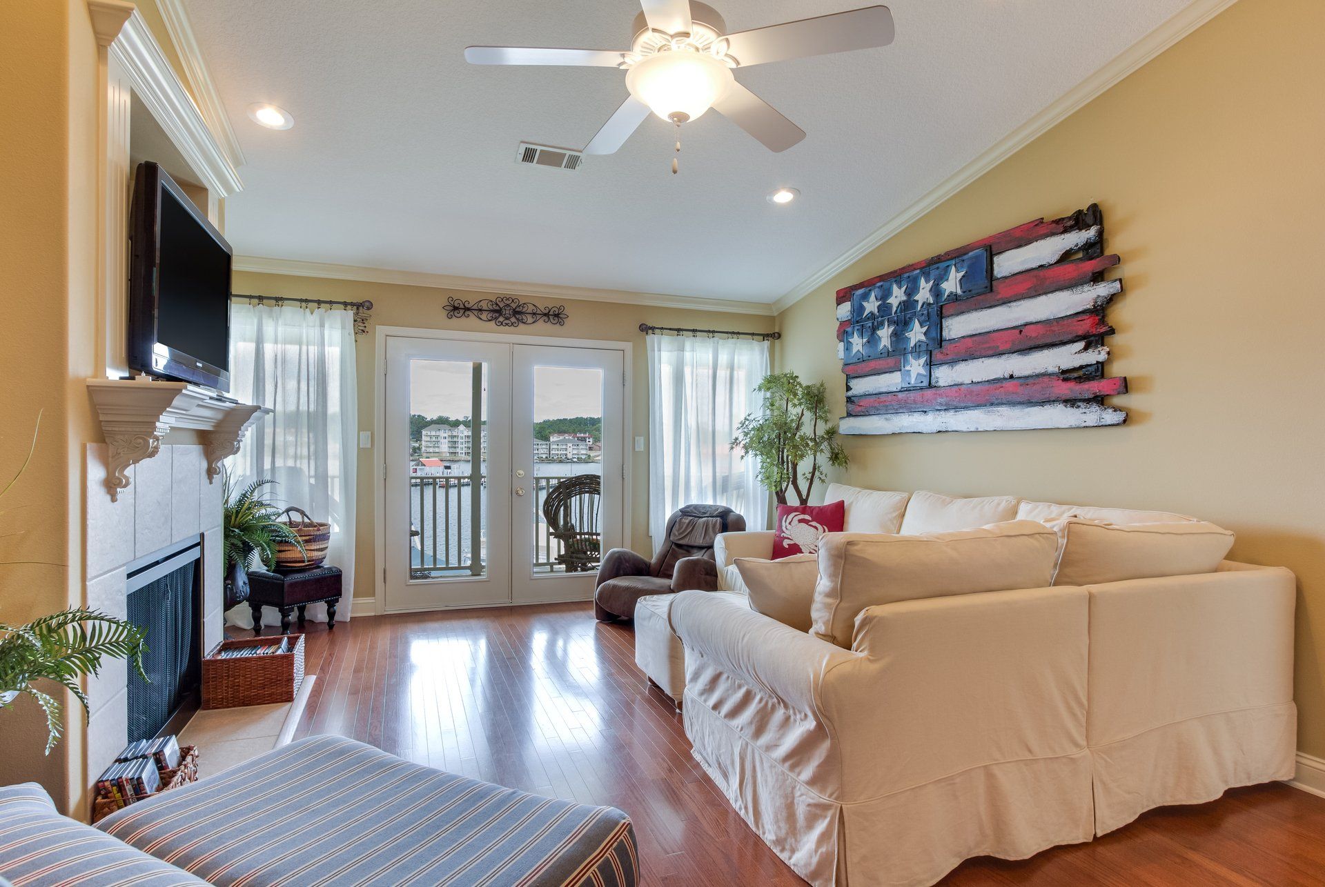 A living room with a couch , fireplace , television and a ceiling fan.