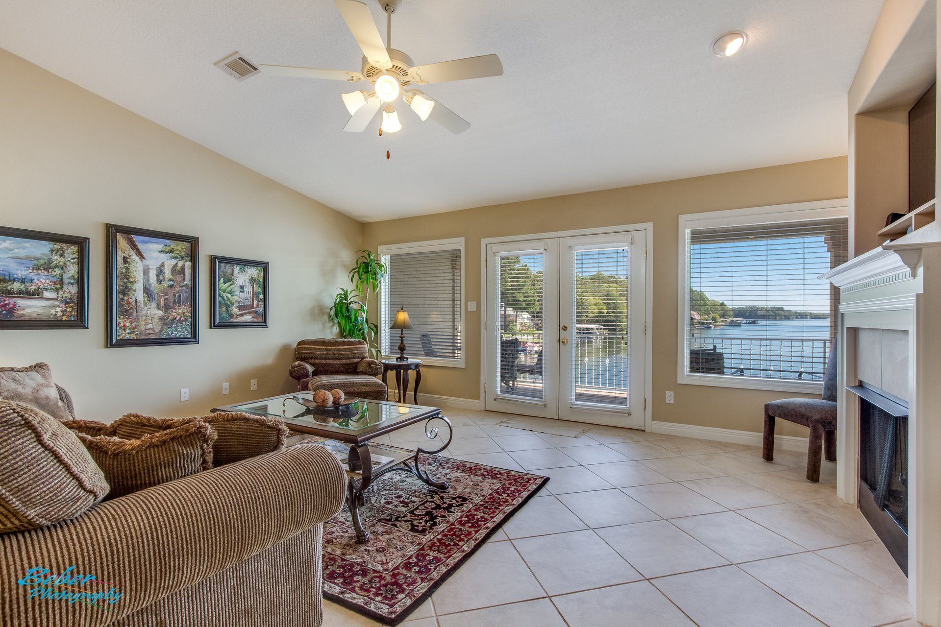 A living room with a couch , fireplace , and ceiling fan.