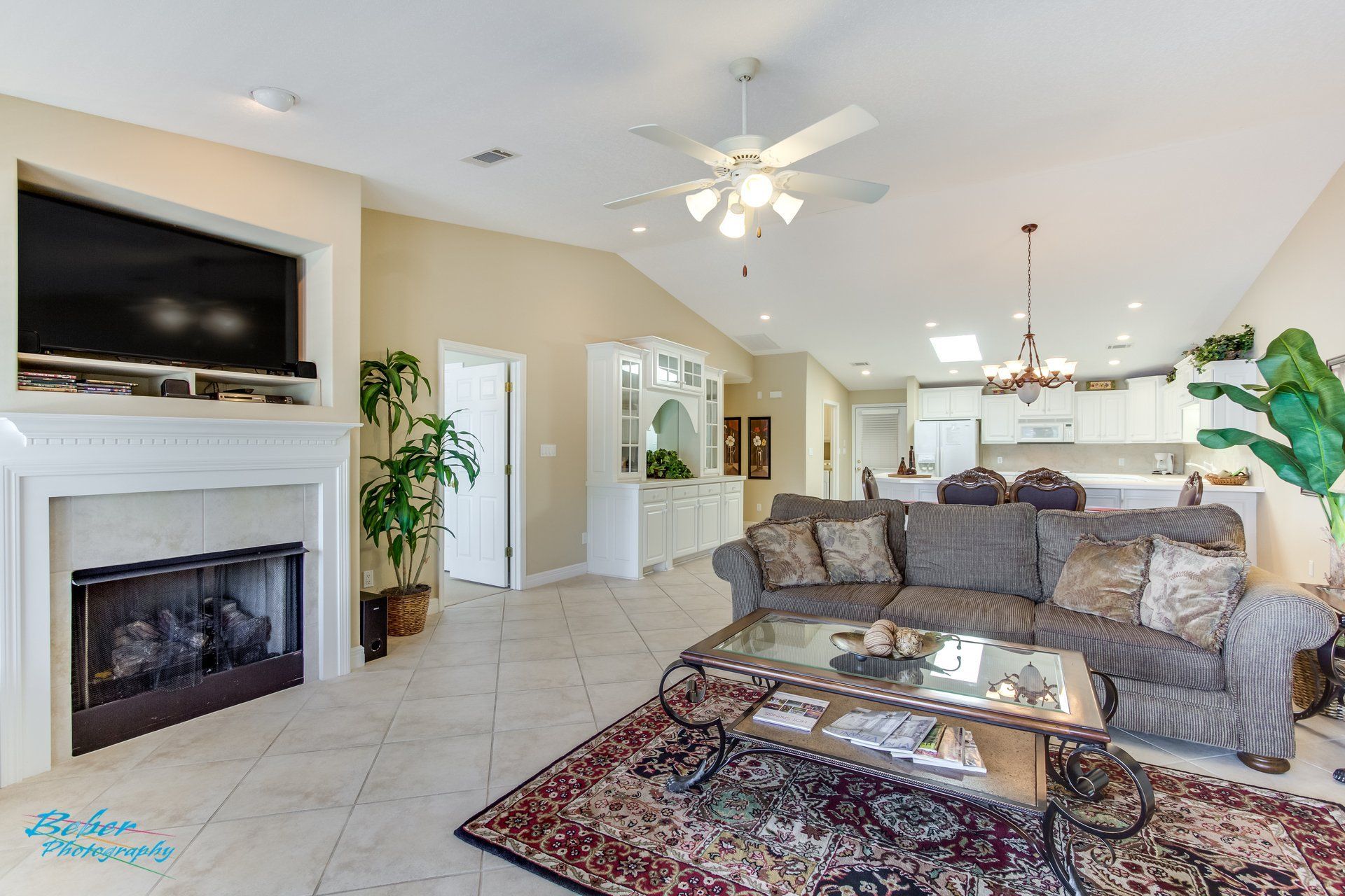 A living room with a couch , coffee table , fireplace and television.