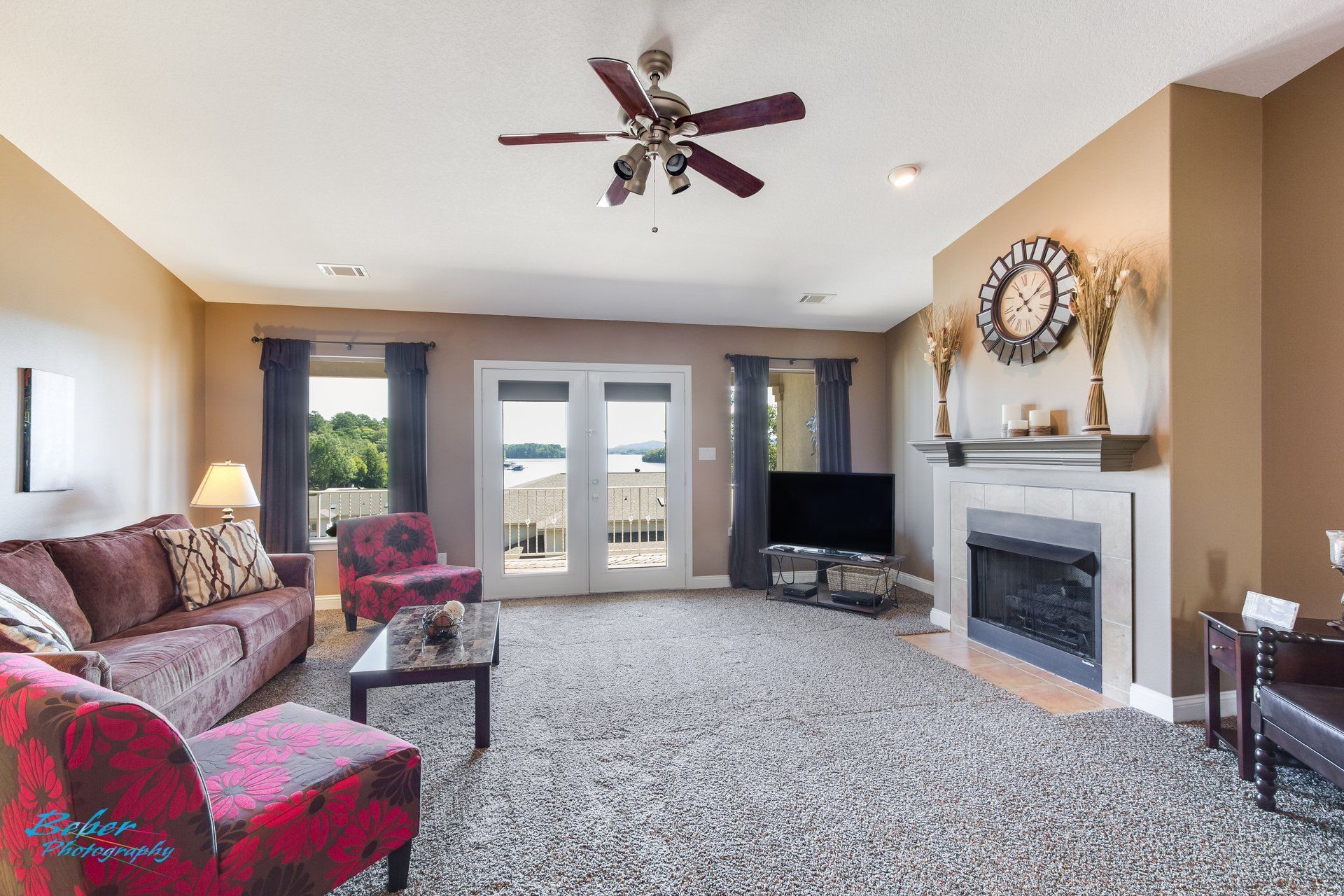 A living room with a fireplace and a ceiling fan