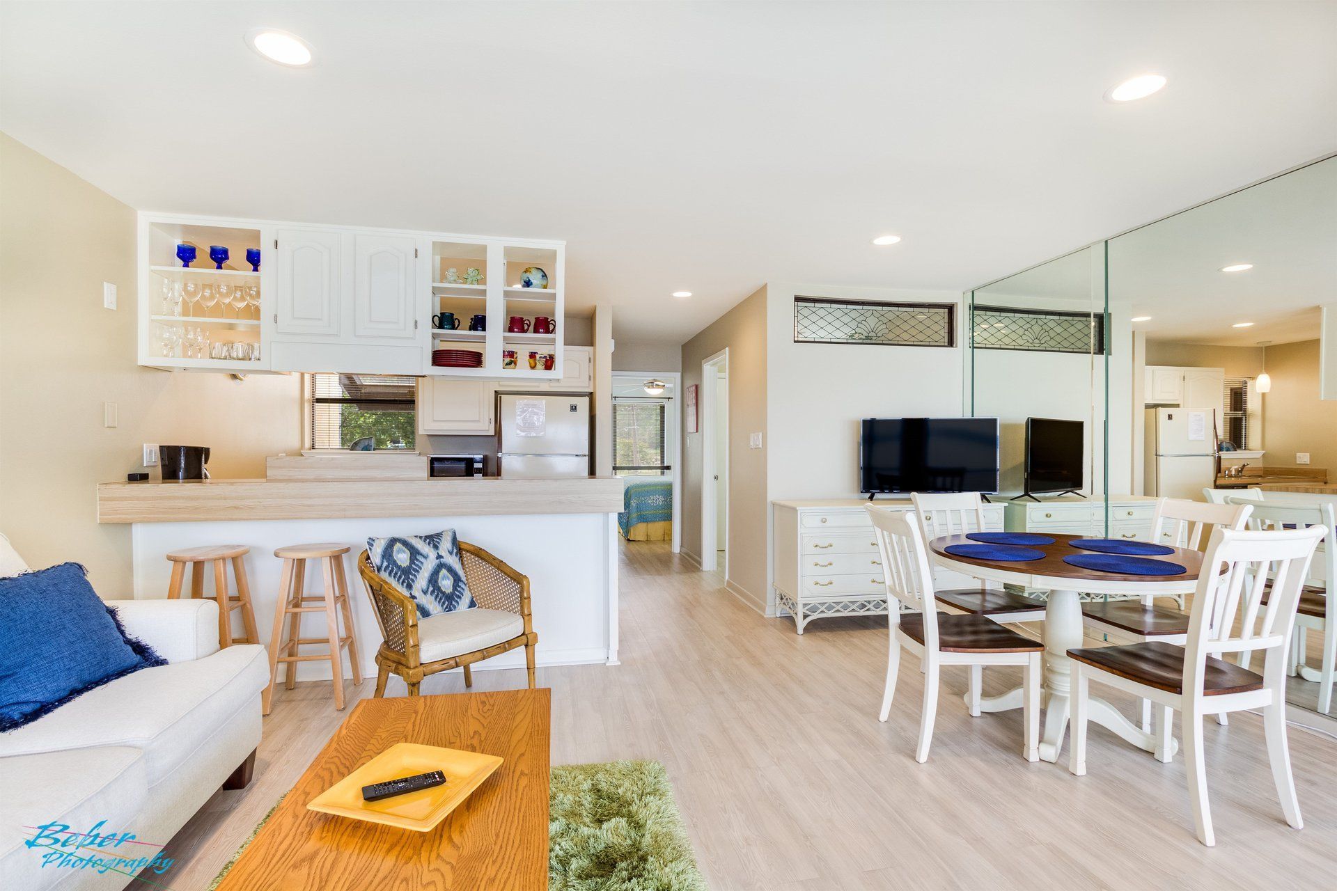 A living room with a couch , table , chairs and a television.
