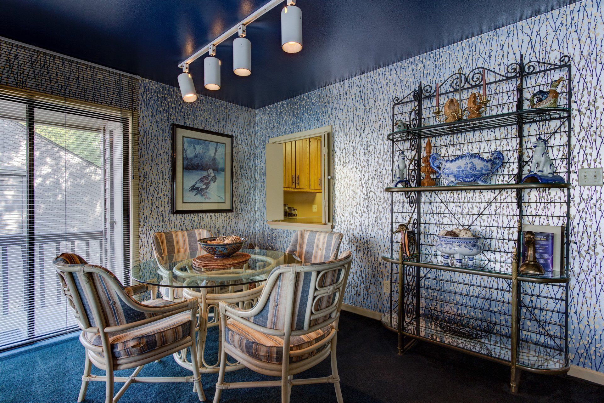 A dining room with a table and chairs and a blue ceiling.