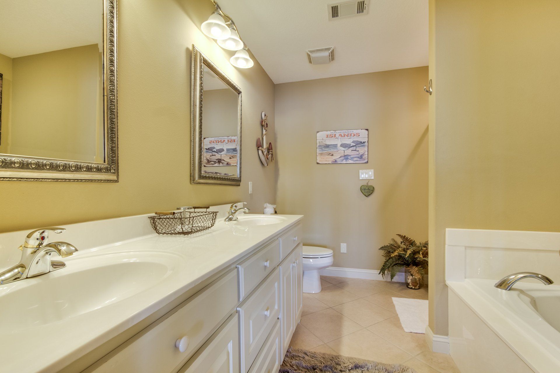 A bathroom with two sinks , a toilet , and a tub.