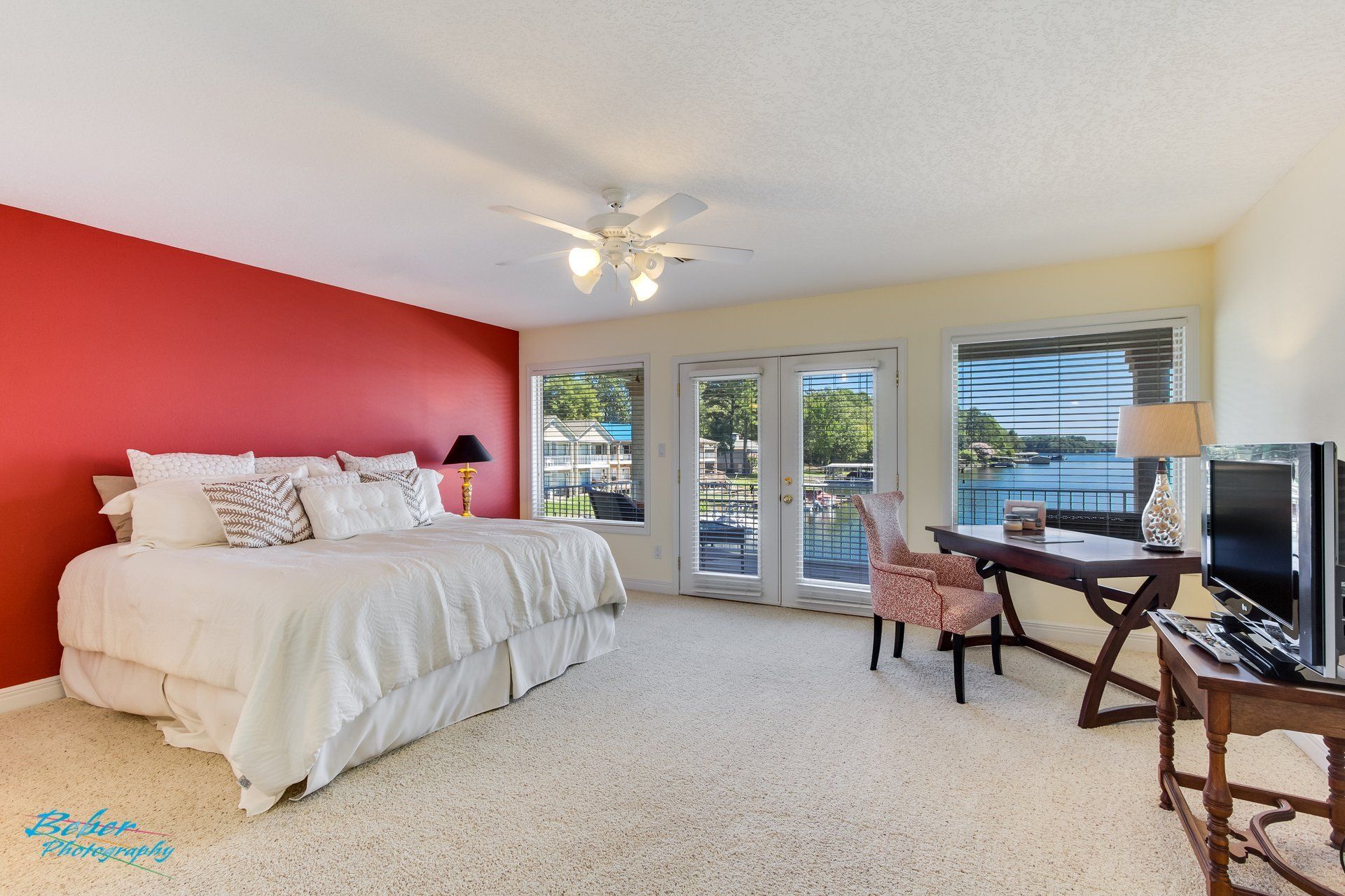 A bedroom with a large bed , desk , chair and television.