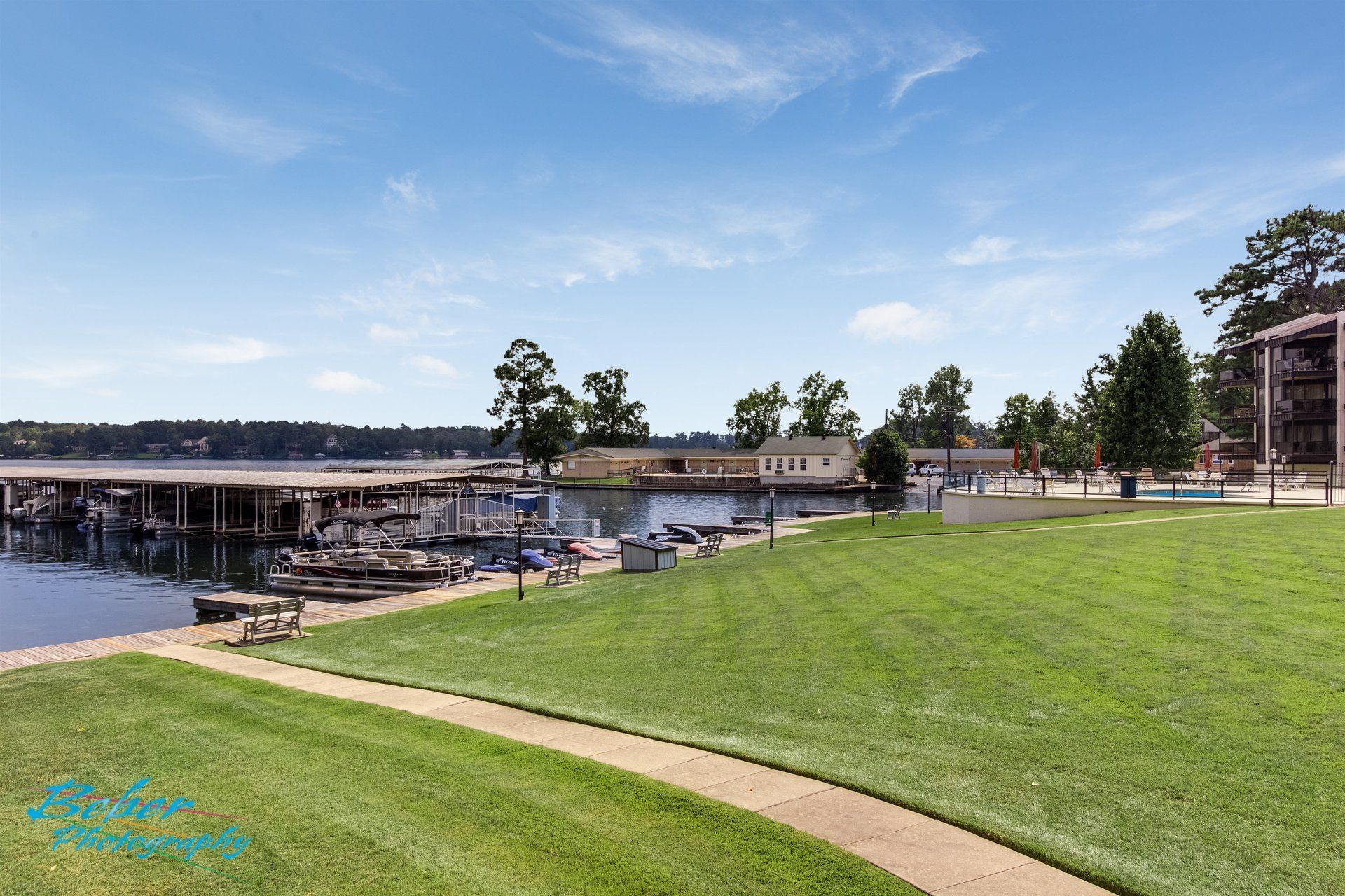 A large lawn with a walkway leading to a body of water.