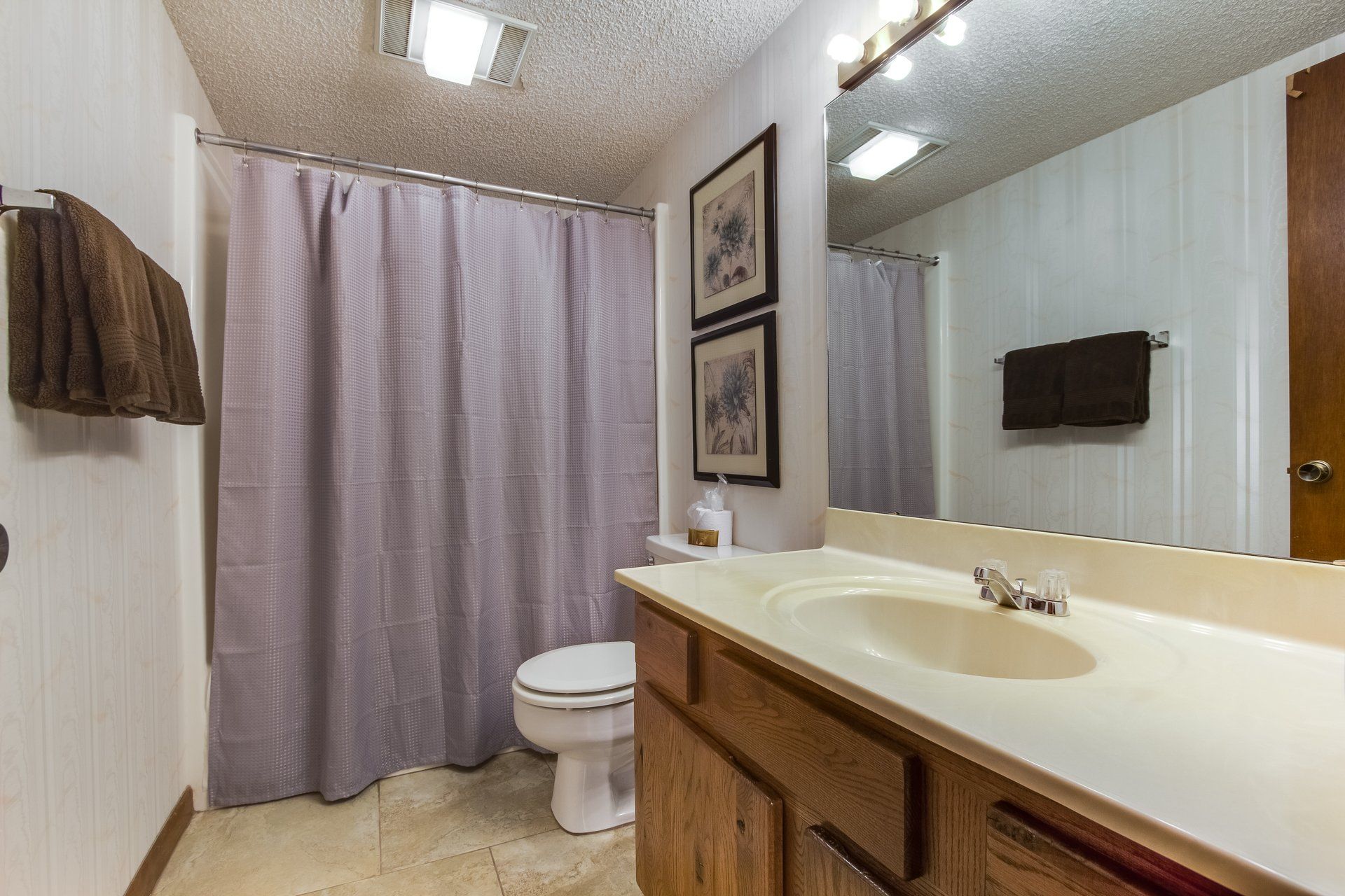 A bathroom with a toilet , sink and mirror