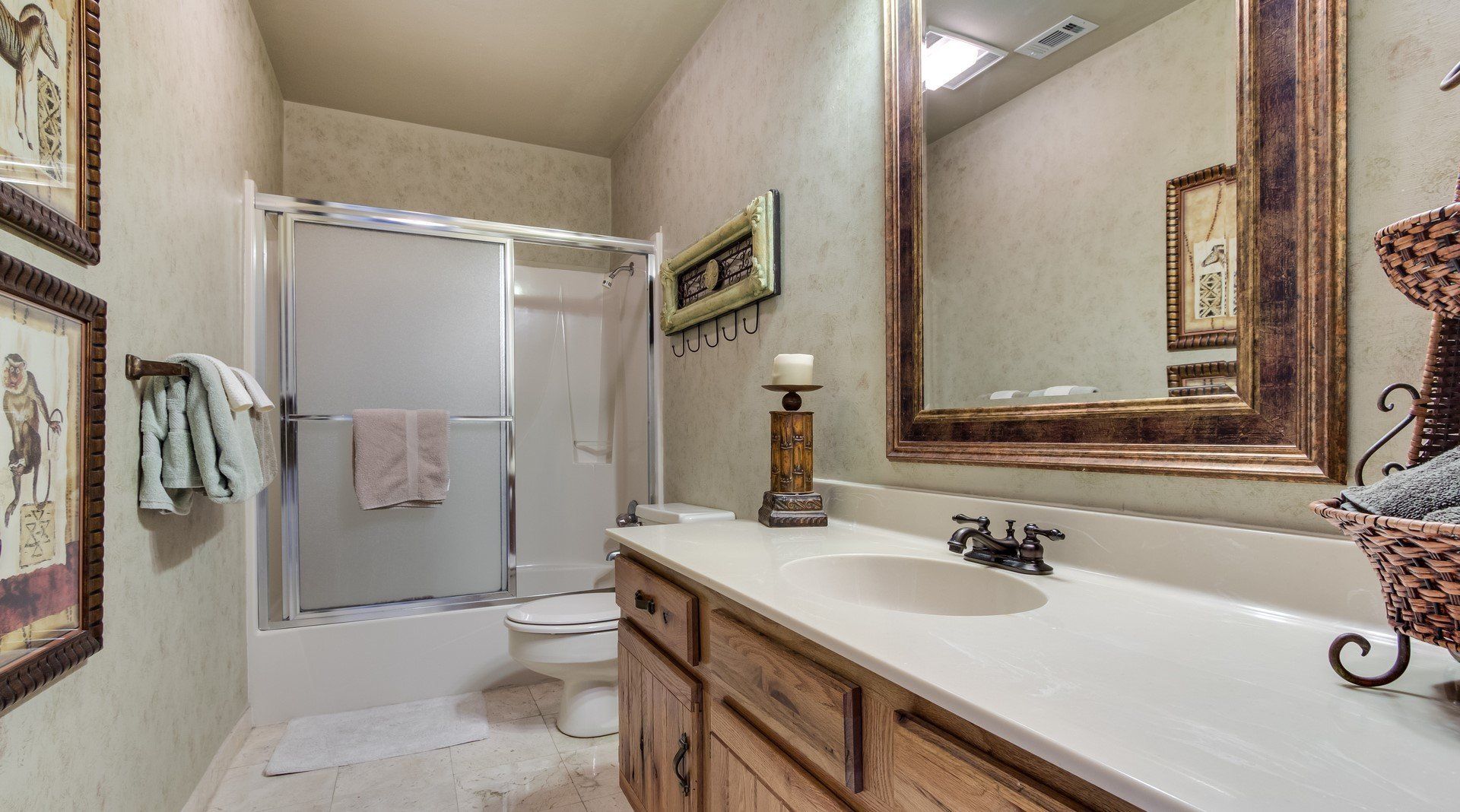 A bathroom with a sink , toilet , shower and mirror.