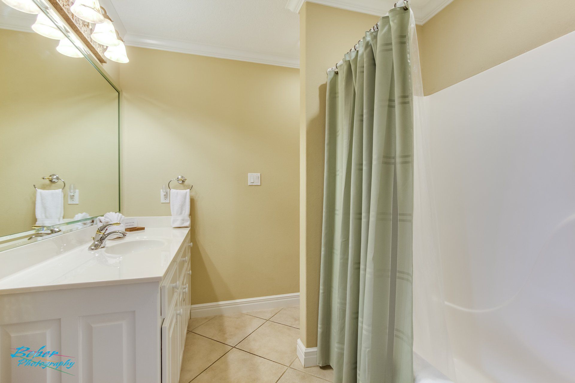 A bathroom with a sink , shower , and mirror.