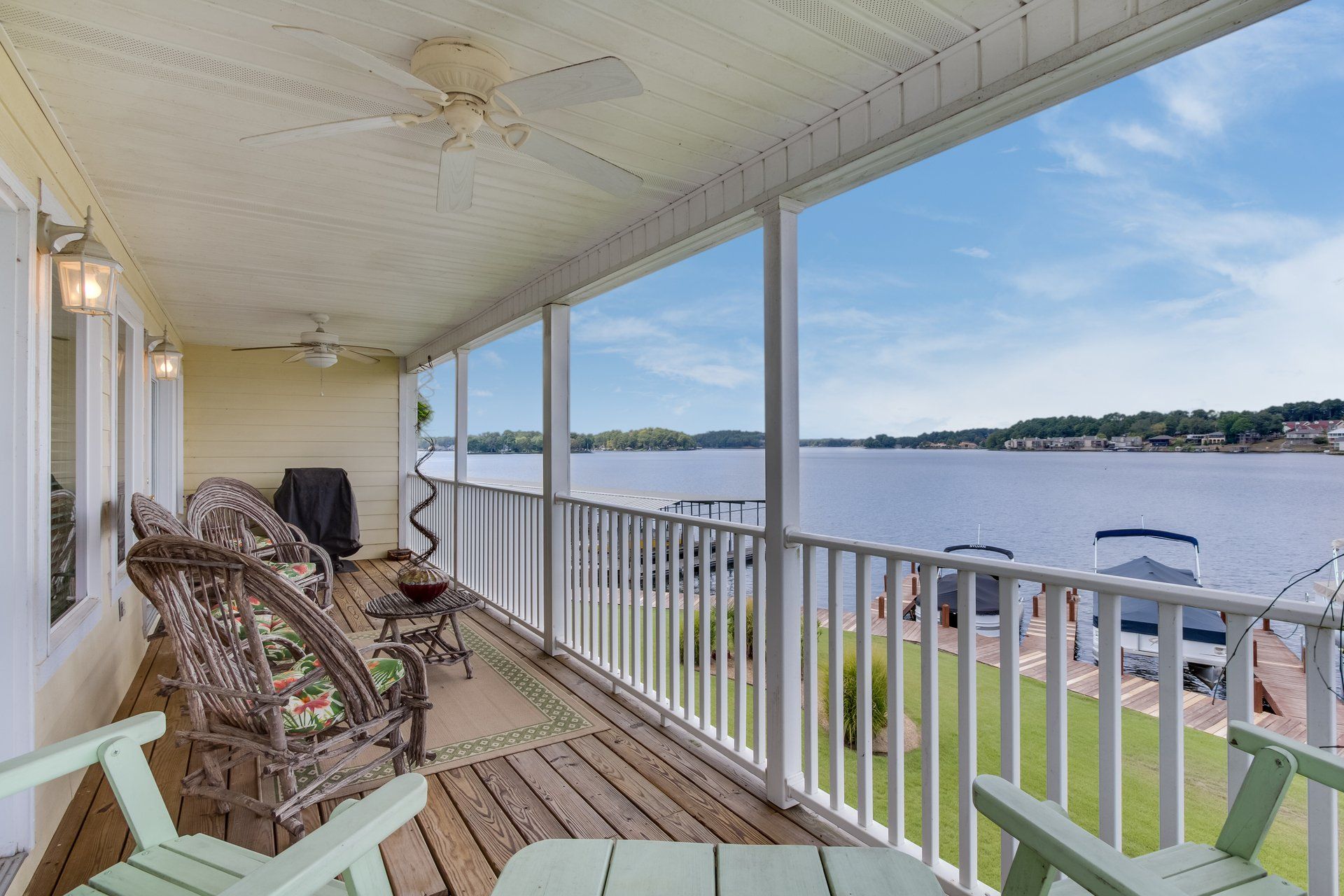 A porch with chairs and a view of a lake.