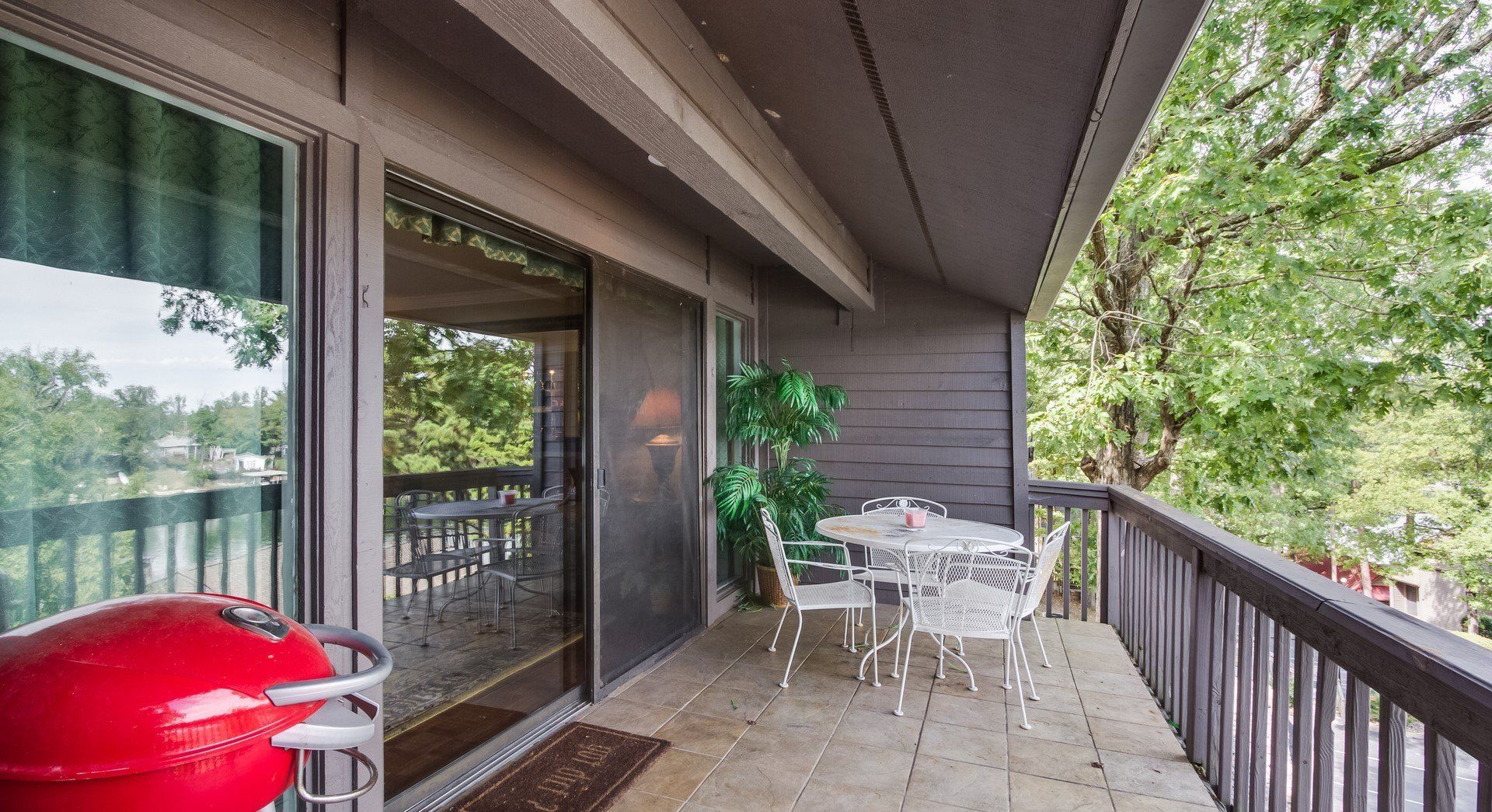 A balcony with a table and chairs and a grill