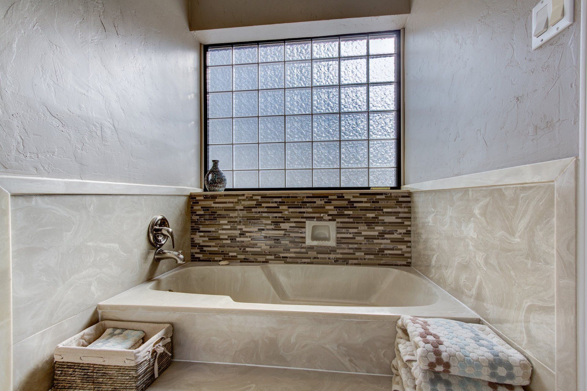 A bathroom with a bathtub and a window