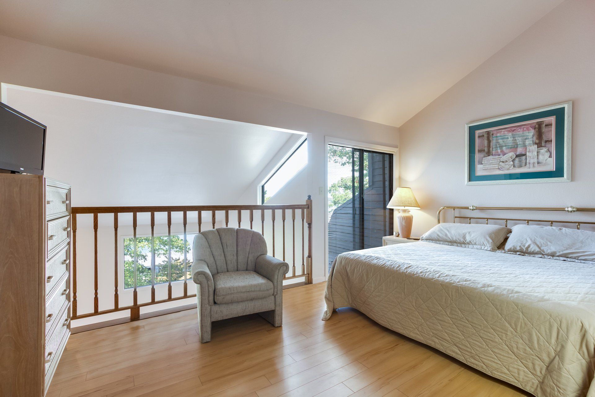 A bedroom with a king size bed and a chair