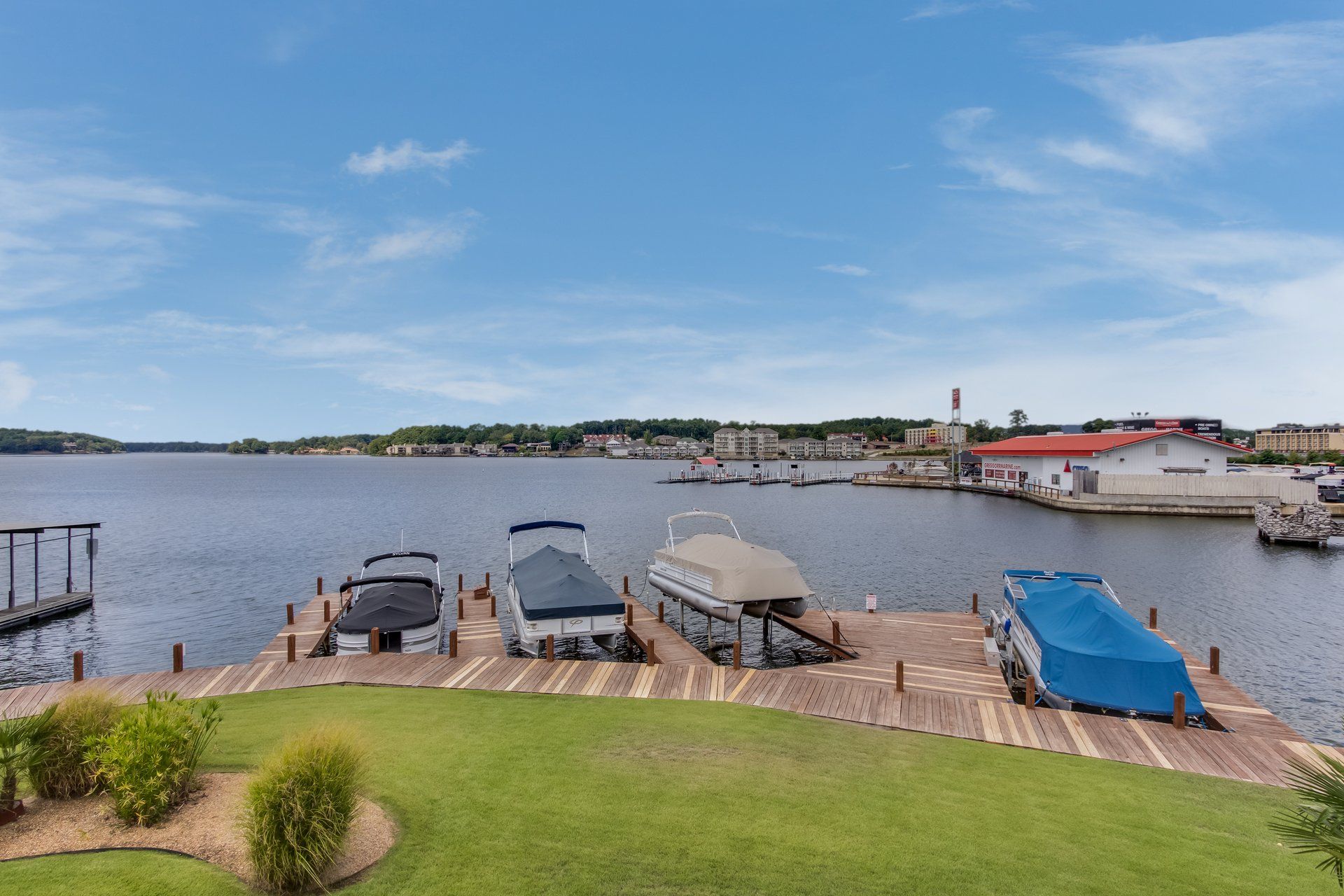 A group of boats are docked at a dock on a lake.
