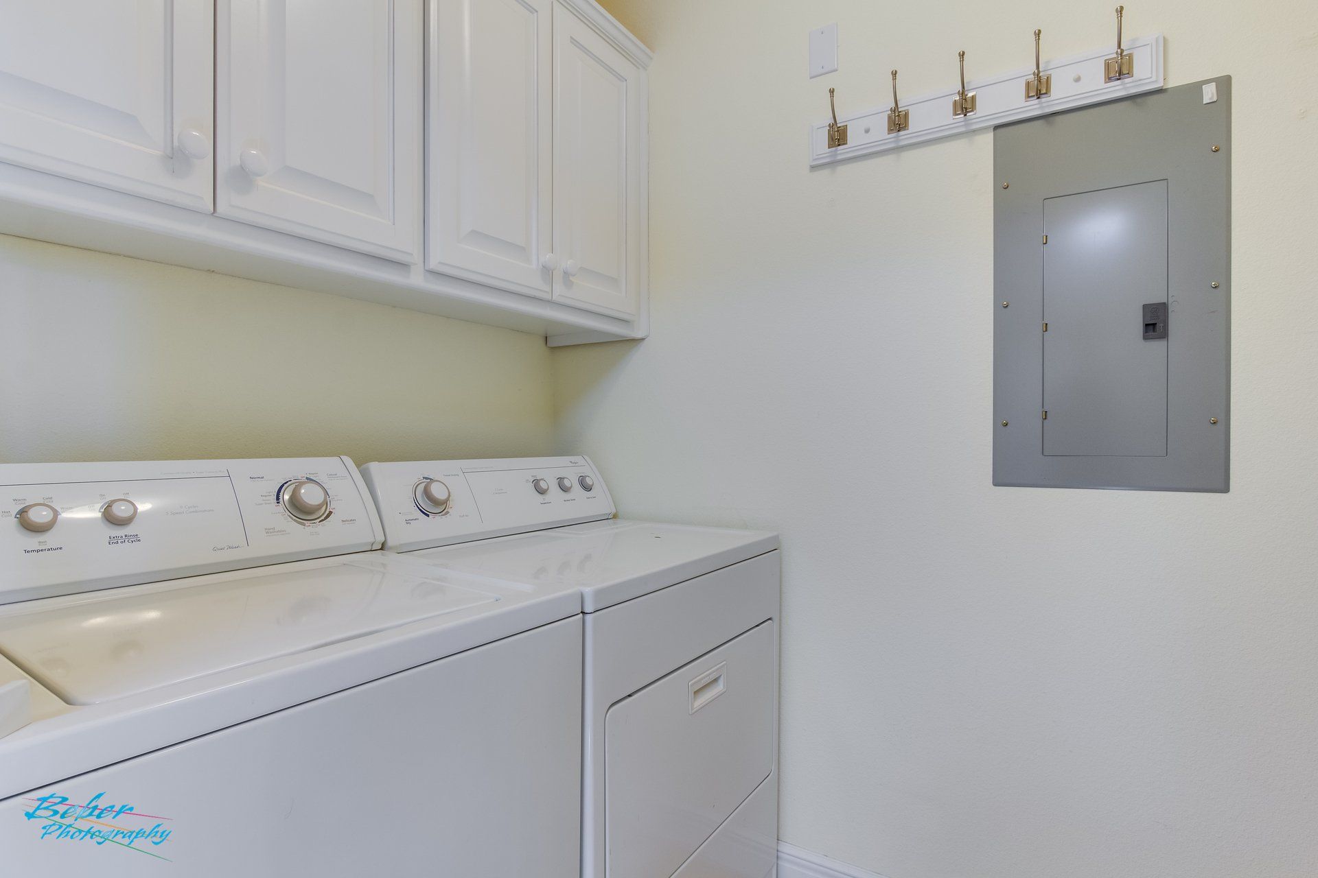 A laundry room with a washer and dryer and a mirror.