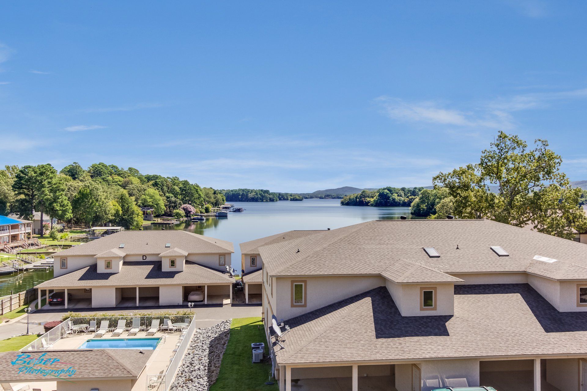 An aerial view of a house with a lake in the background