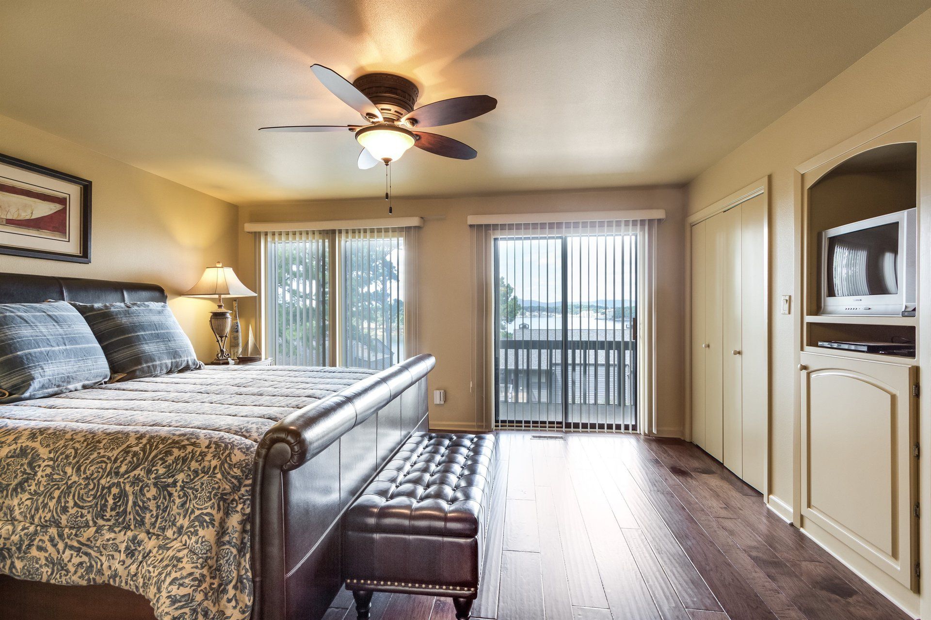 A bedroom with a large bed and a ceiling fan