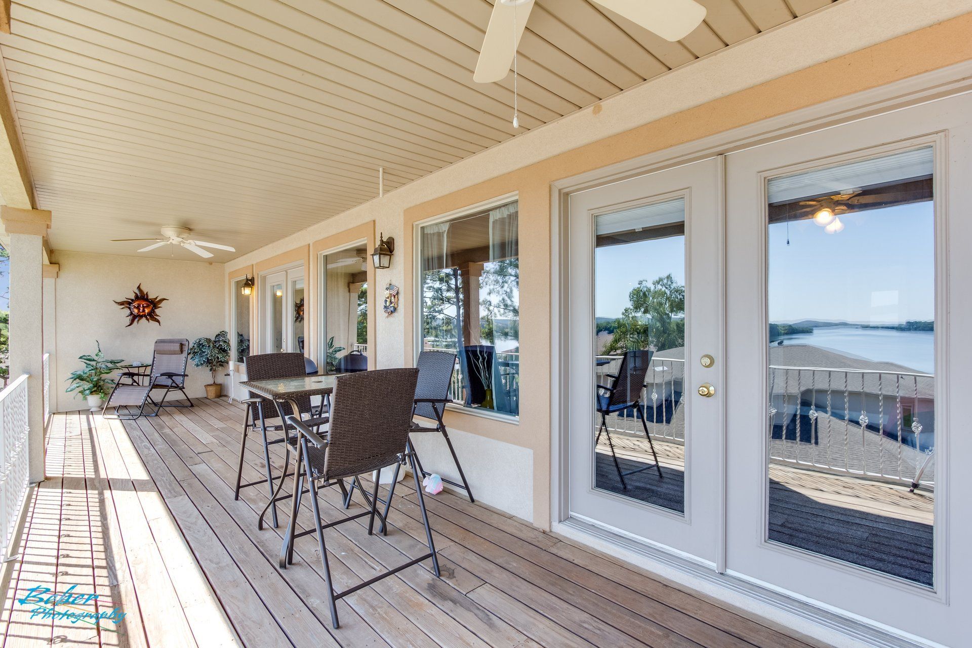 A large deck with a table and chairs and a ceiling fan