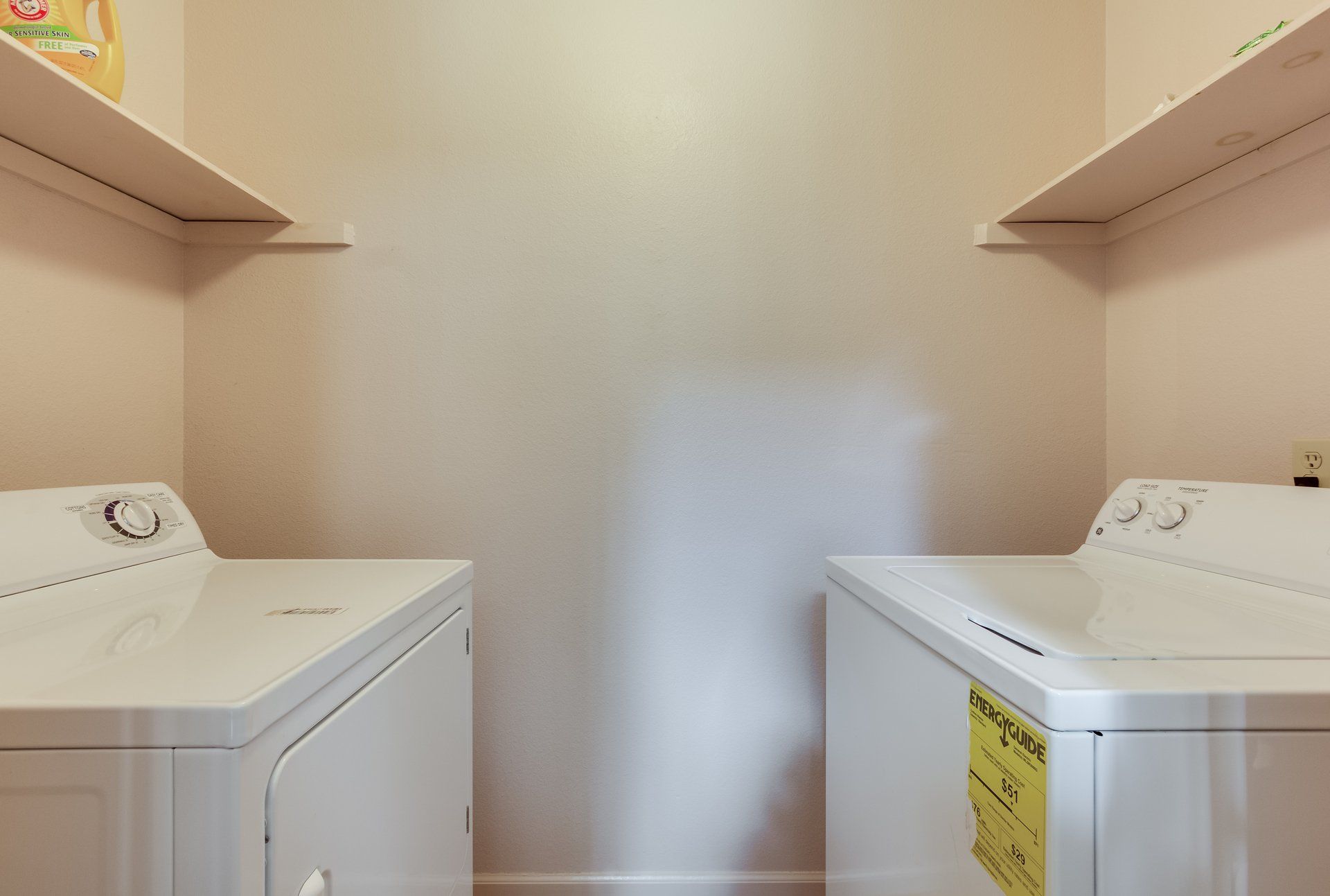 A laundry room with two white washers and dryers.