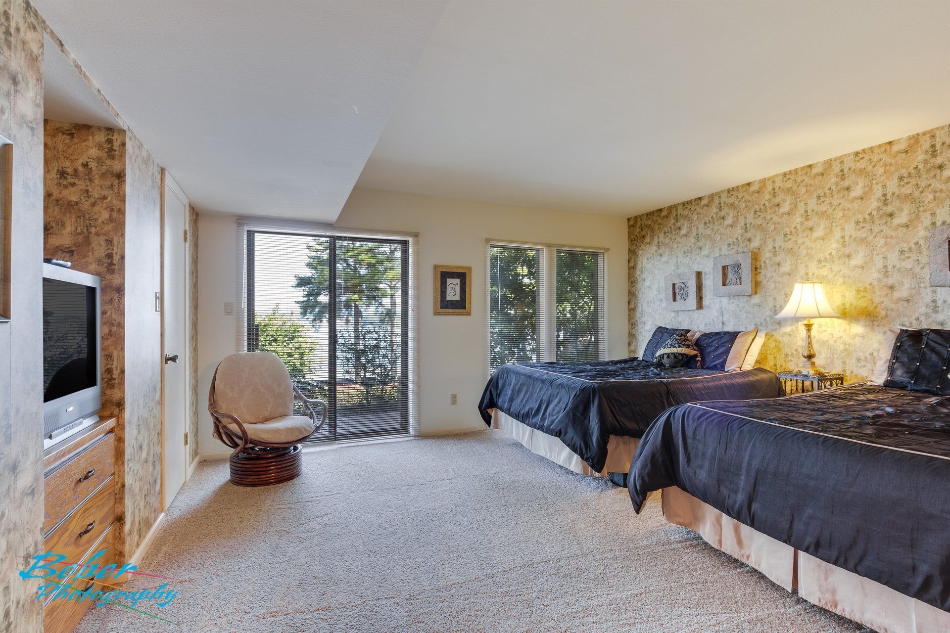 A bedroom with two beds , a chair and a television.