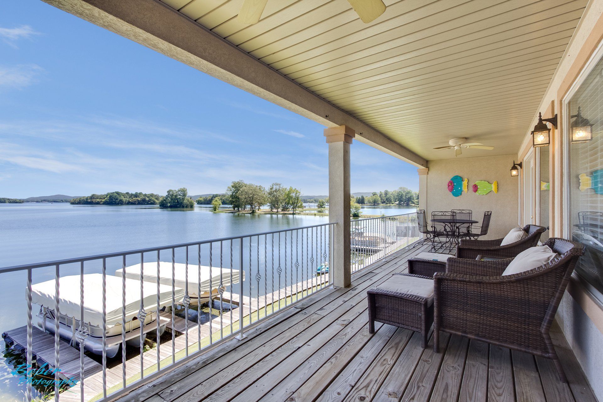 A large deck with a view of a lake and a dock.