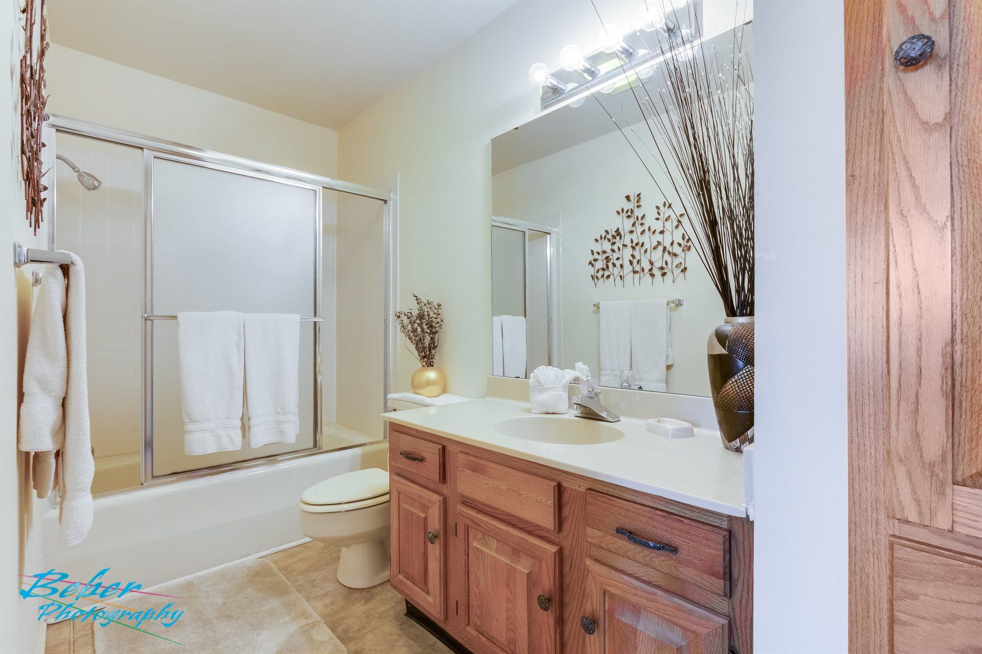 A bathroom with a sink , toilet , tub and mirror.