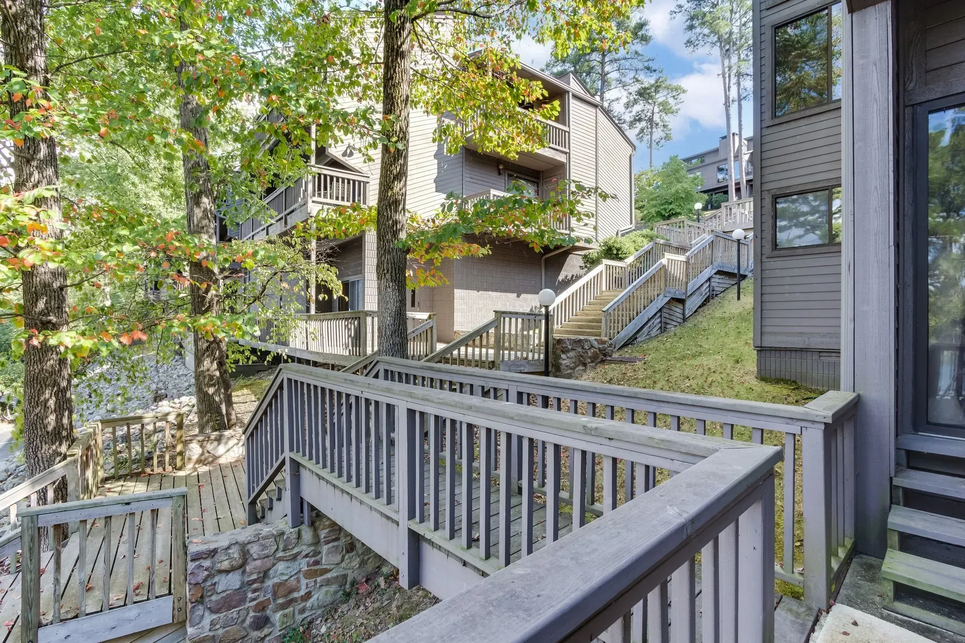 A wooden deck with stairs leading up to a house.