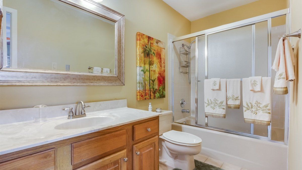 A bathroom with a sink , toilet , bathtub and mirror.