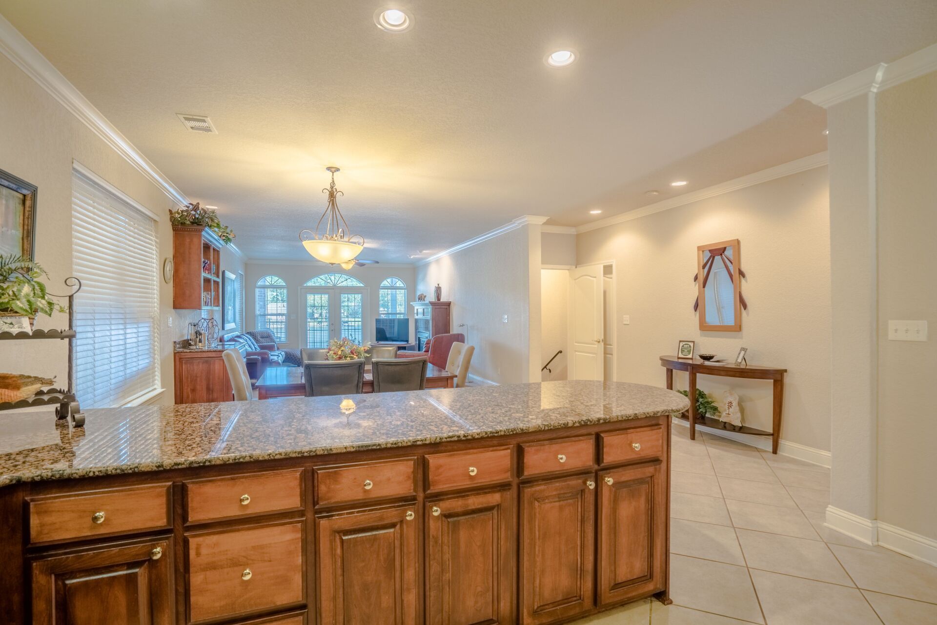 A kitchen with granite counter tops and wooden cabinets.