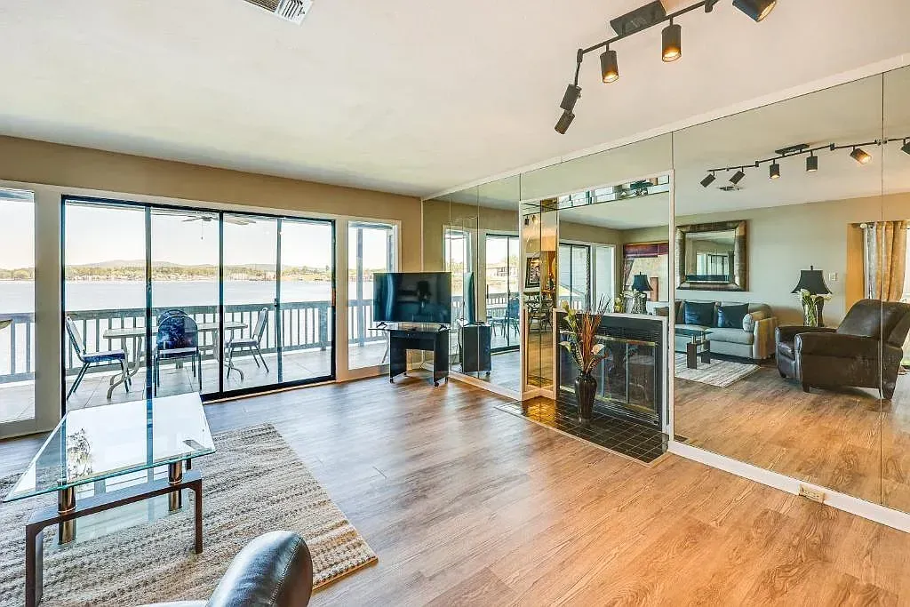 A living room with a lot of windows and a large mirror on the wall.