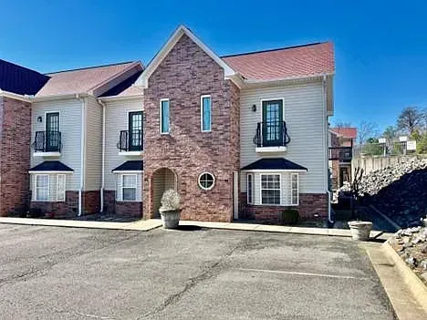 A large apartment building with a parking lot in front of it.