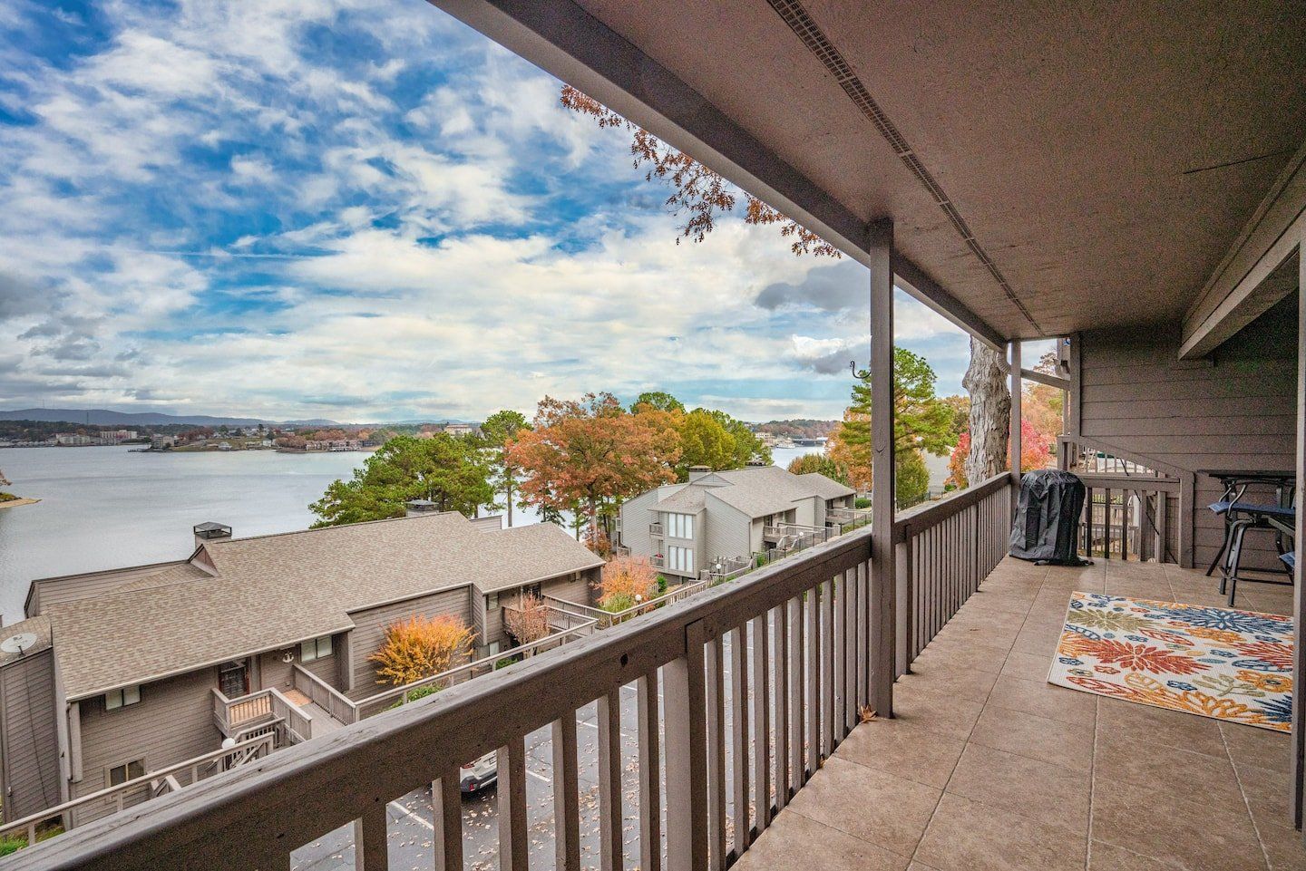 A balcony with a view of a lake and houses.