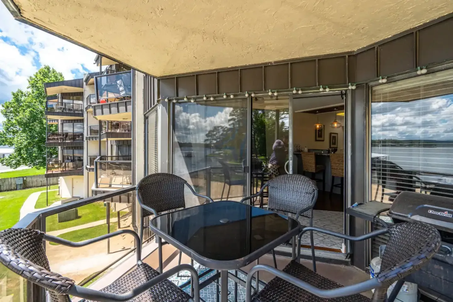 A balcony with a table and chairs overlooking a body of water.