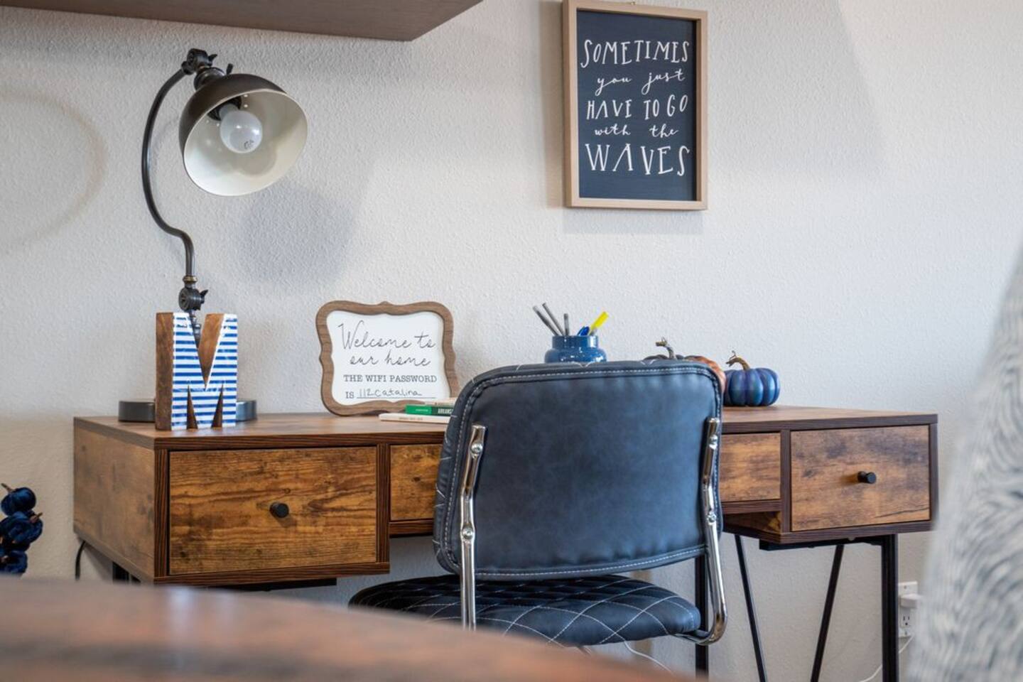 A desk with a chair and a lamp on it in a room.
