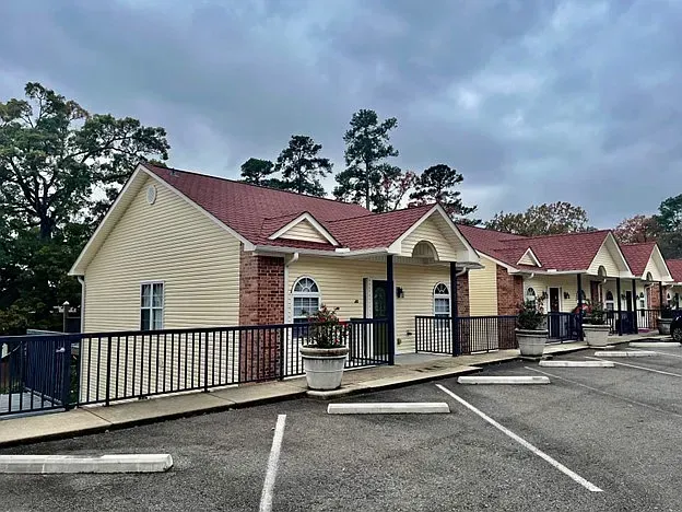 A row of small houses with red roofs are lined up in a parking lot.
