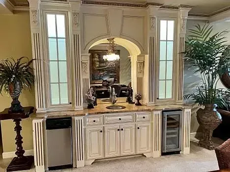 A living room with a bar and a dining room in the background.