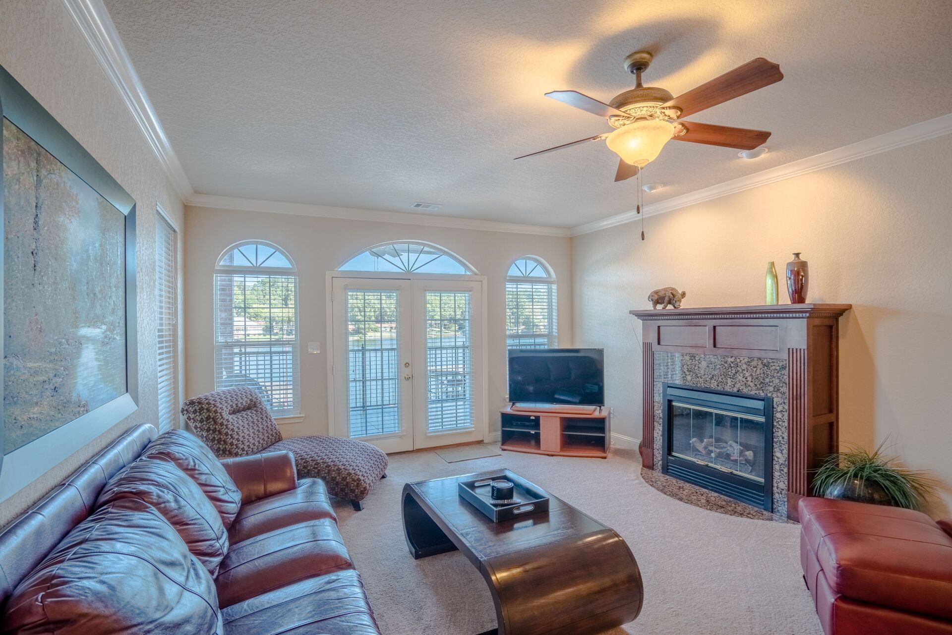 A living room with a fireplace and a ceiling fan