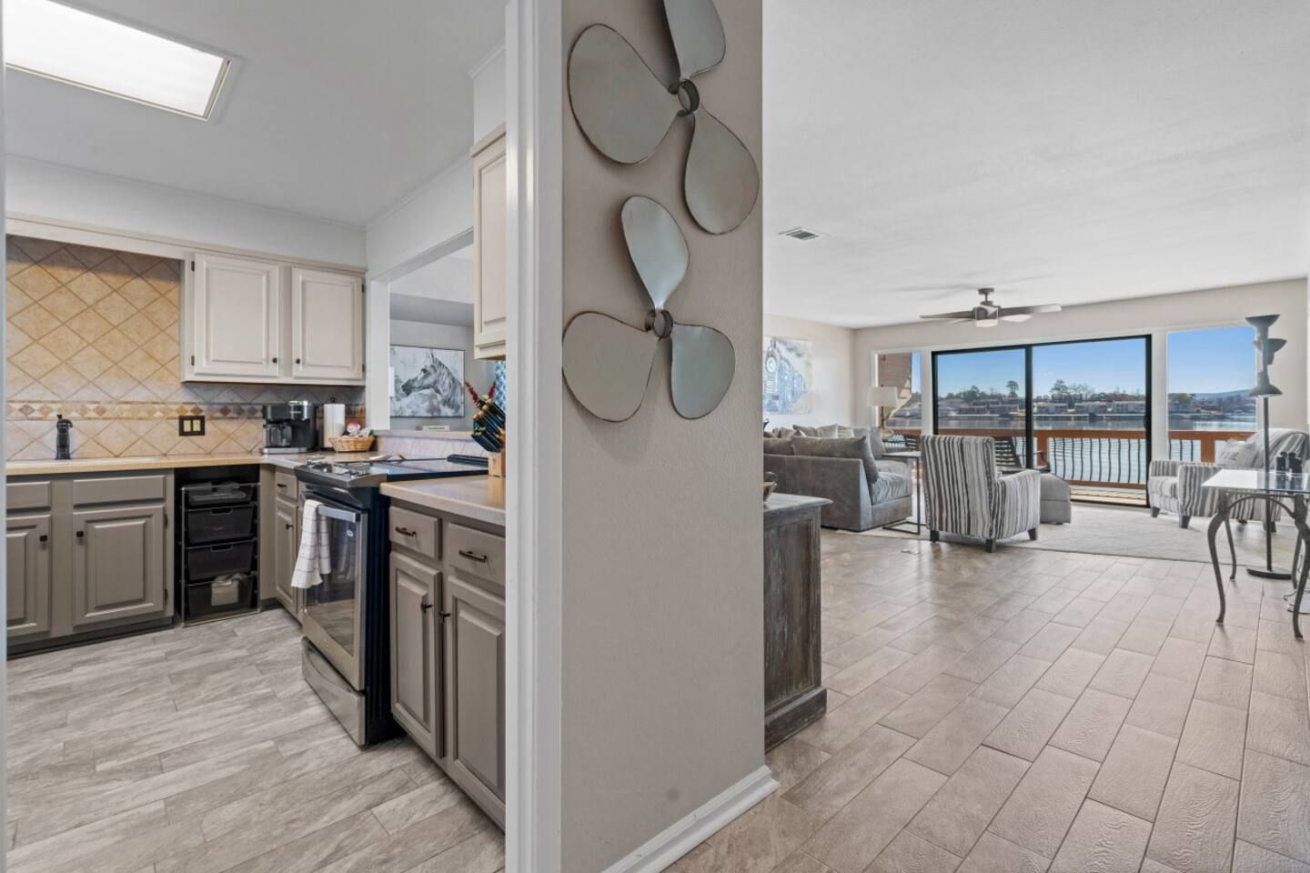 A kitchen and living room in a house with a view of the ocean.