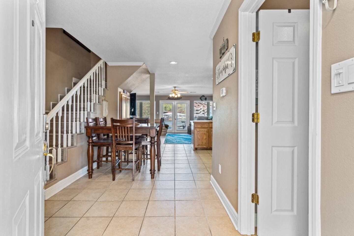 A hallway in a house with a table and chairs in it.