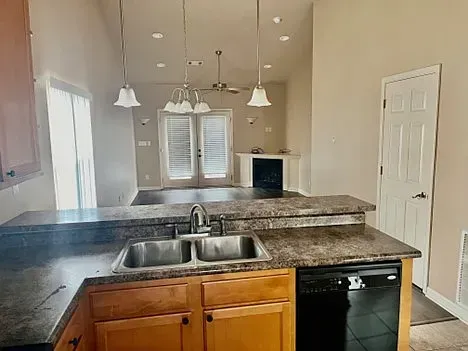 A kitchen with a sink and a dishwasher in a house.