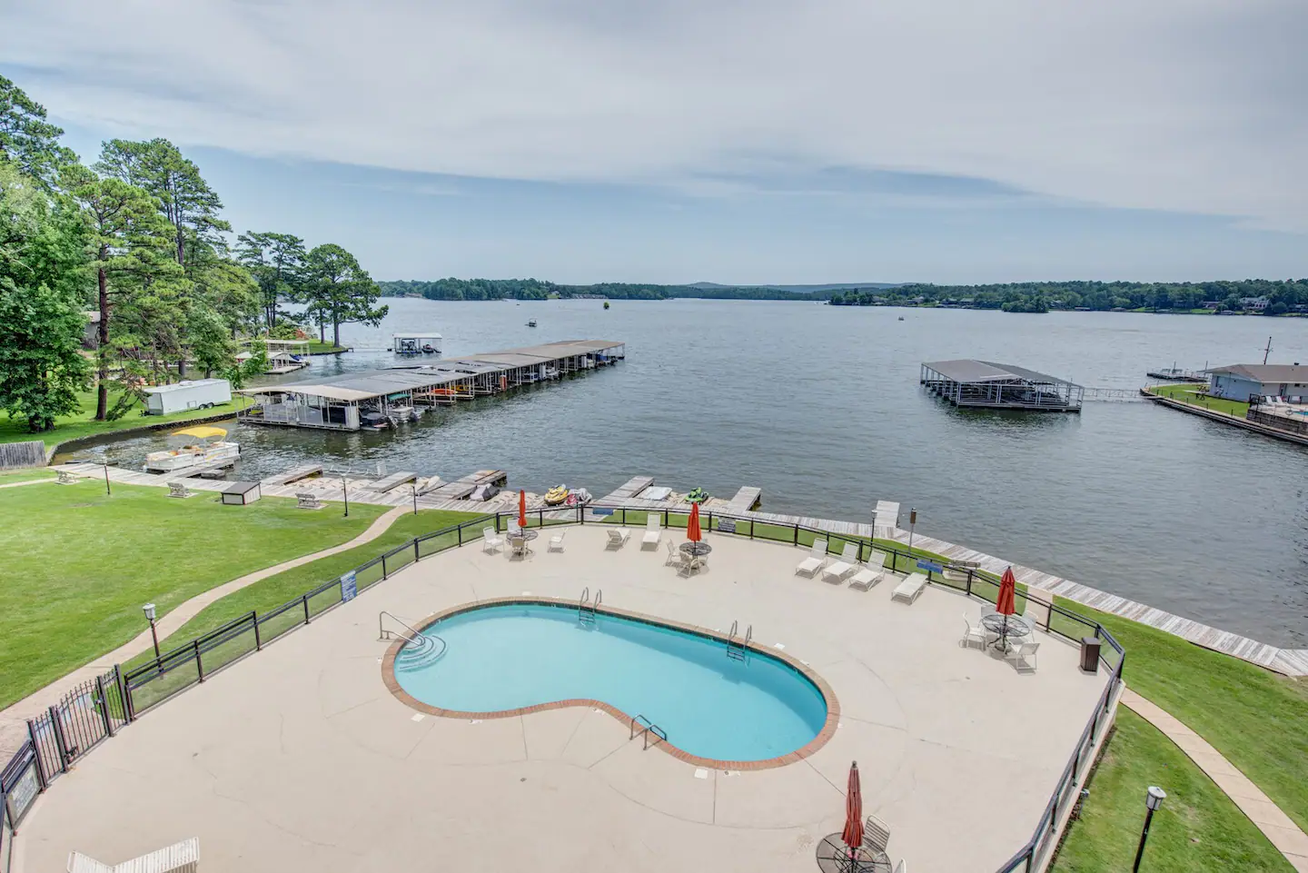 An aerial view of a large swimming pool next to a lake.