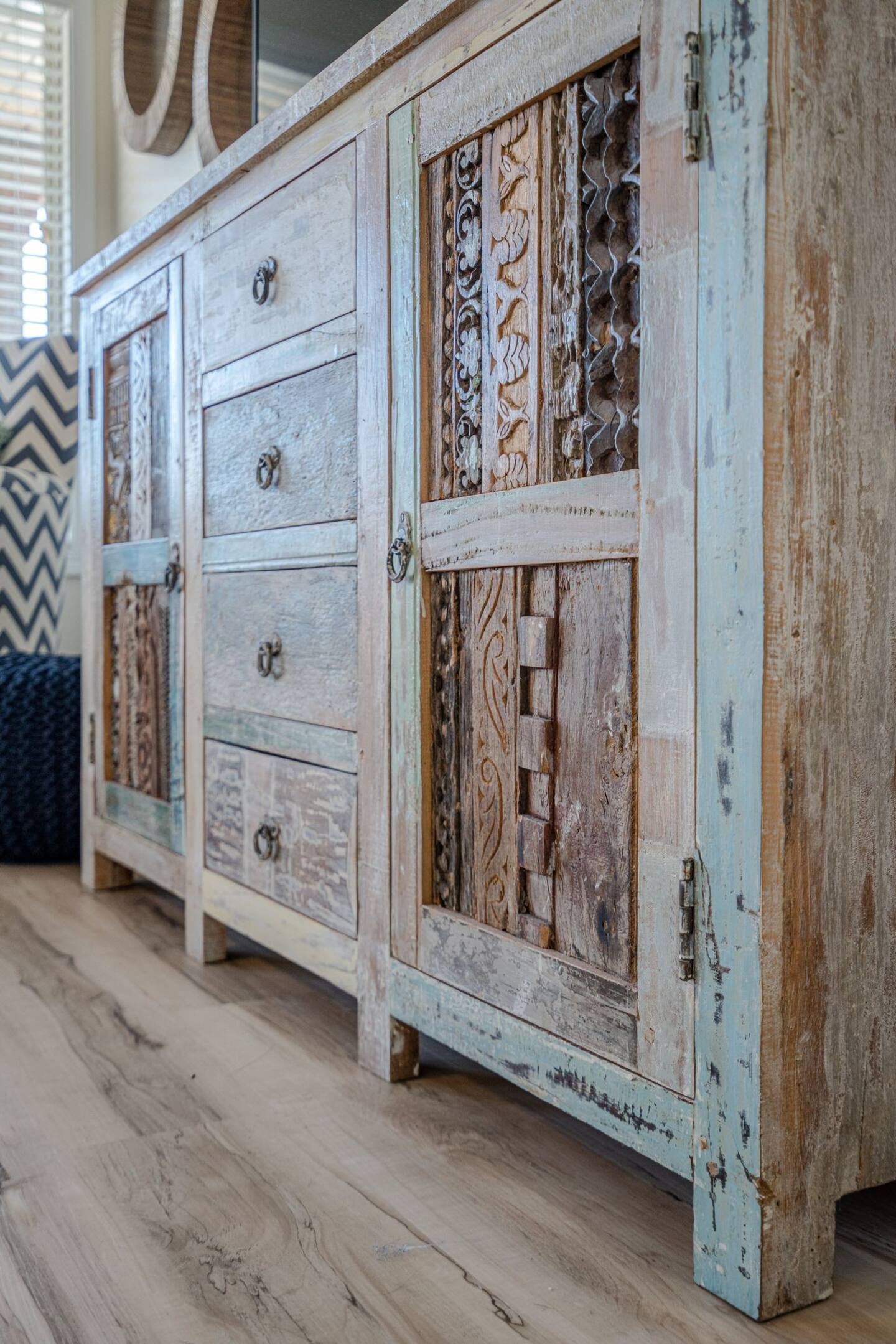 A wooden dresser with drawers and doors is sitting on a wooden floor.