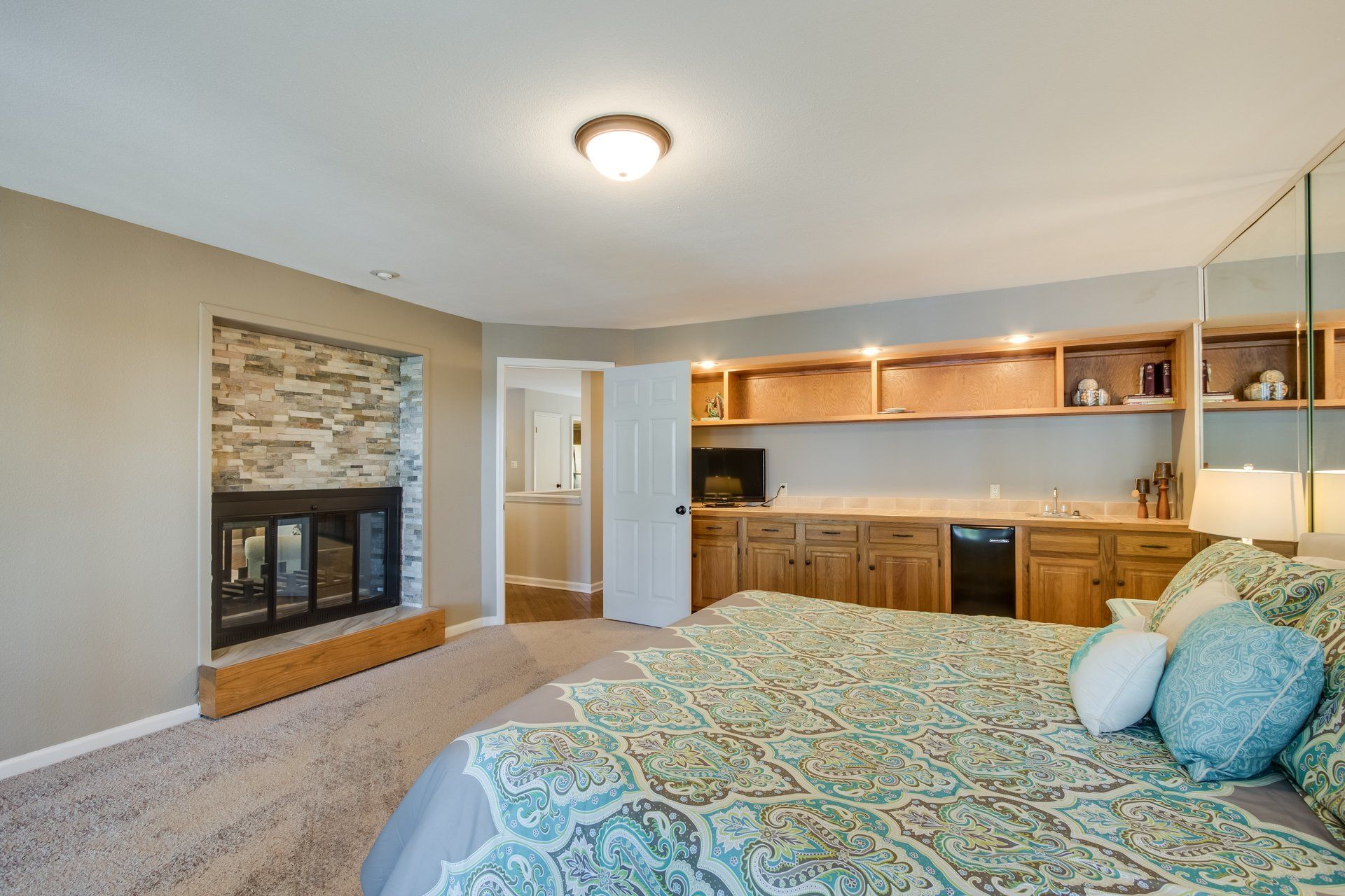 A bedroom with a large bed and a fireplace.
