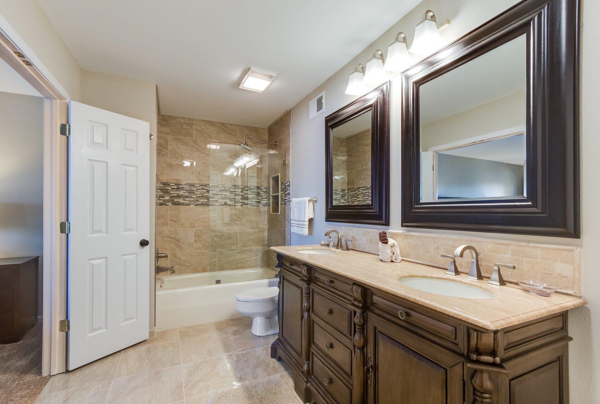 A bathroom with two sinks , a toilet , and a bathtub.