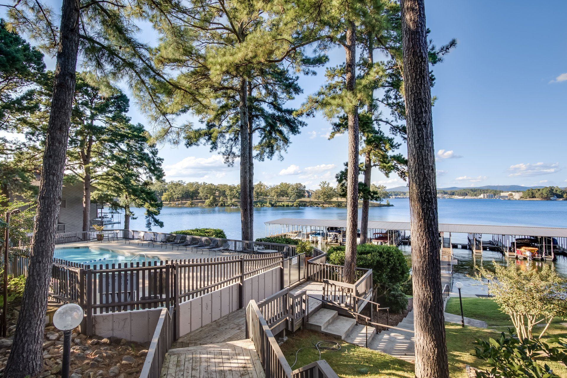 A view of a lake from a staircase surrounded by trees