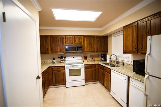 A kitchen with white appliances and wooden cabinets