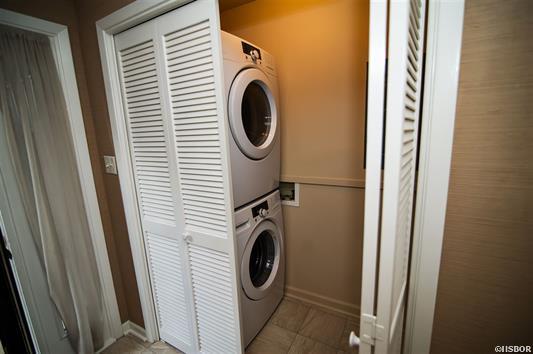 A washer and dryer are stacked on top of each other in a laundry room.
