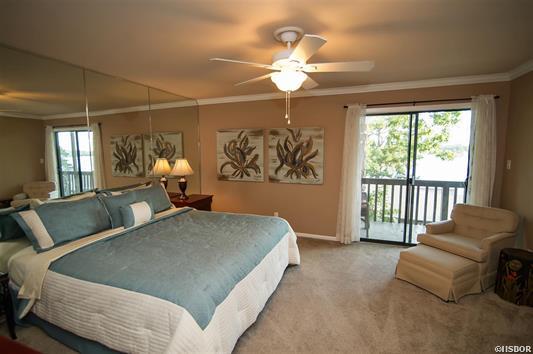 A bedroom with a large bed and a ceiling fan