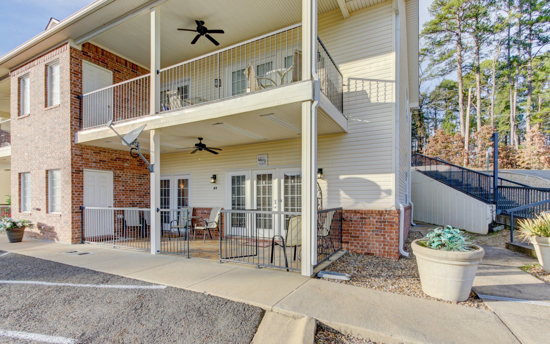 A large apartment building with a balcony and tables and chairs.